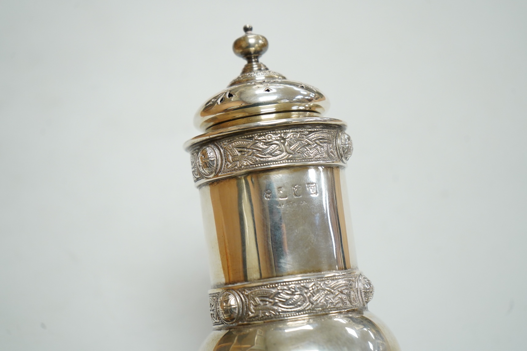 A George V Irish silver sugar caster, by West & Son, Dublin, 1914, decorated with Celtic bands, height 16.7cm, 9.9oz.